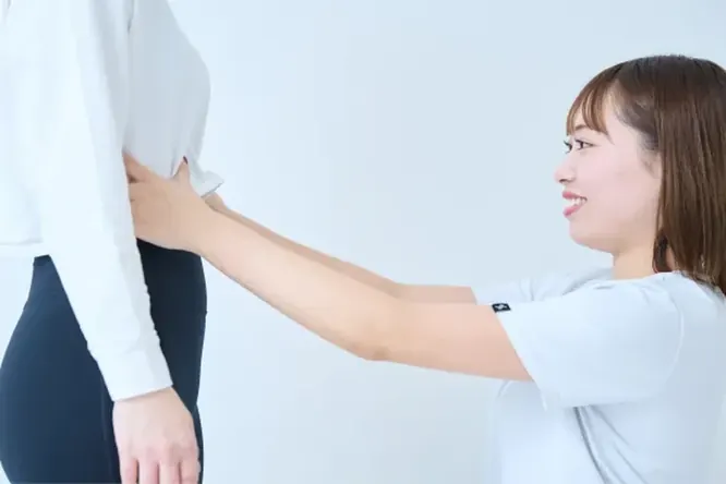 身体の状態を確認するトレーナー