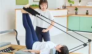 国家資格を持つトレーナーがリフォーマーでマンツーマン指導する様子