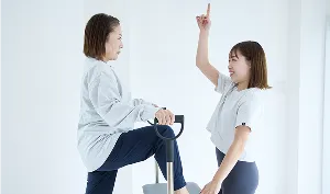 トレーナーがチェアを使って丁寧に指導する様子
