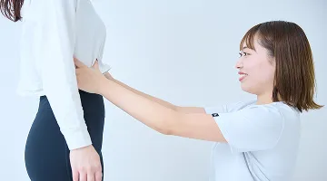 立ち姿勢をチェックするトレーナー（姿勢改善）