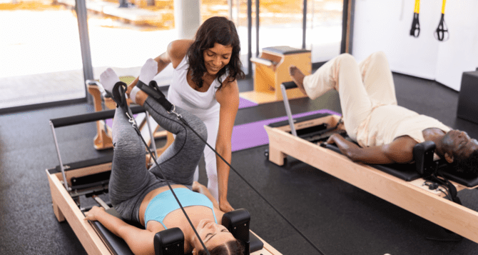 Woman and instructor receiving Pilates with a smile