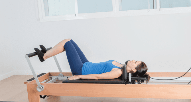 Woman doing shoulder bridge with reformer