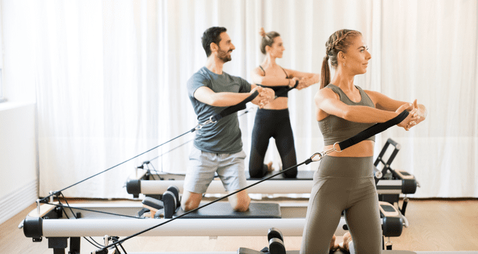 Men and women doing machine Pilates