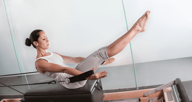 A woman doing sit-ups with a reformer