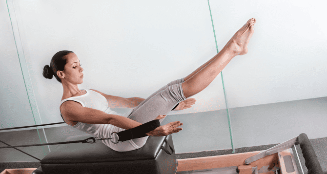 A woman doing a reformer with her head and legs raised