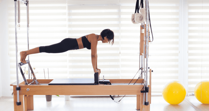 Woman doing reformer in plank position